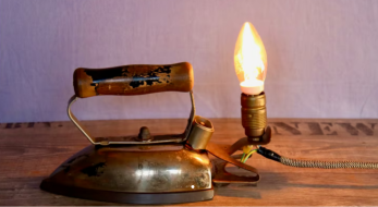 warmes Licht durch Glühbirne an antikem Bügeleisen